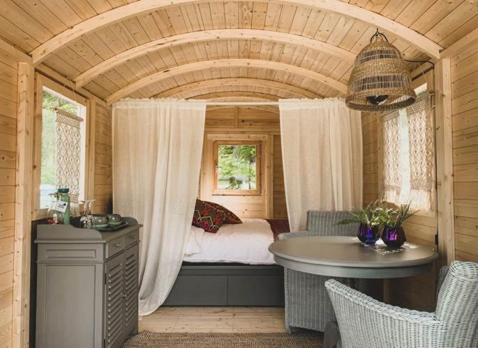 een slaapkamer met een bed en een bad in een kamer bij Roulotte - Camping l'Eau Vive in Martelange