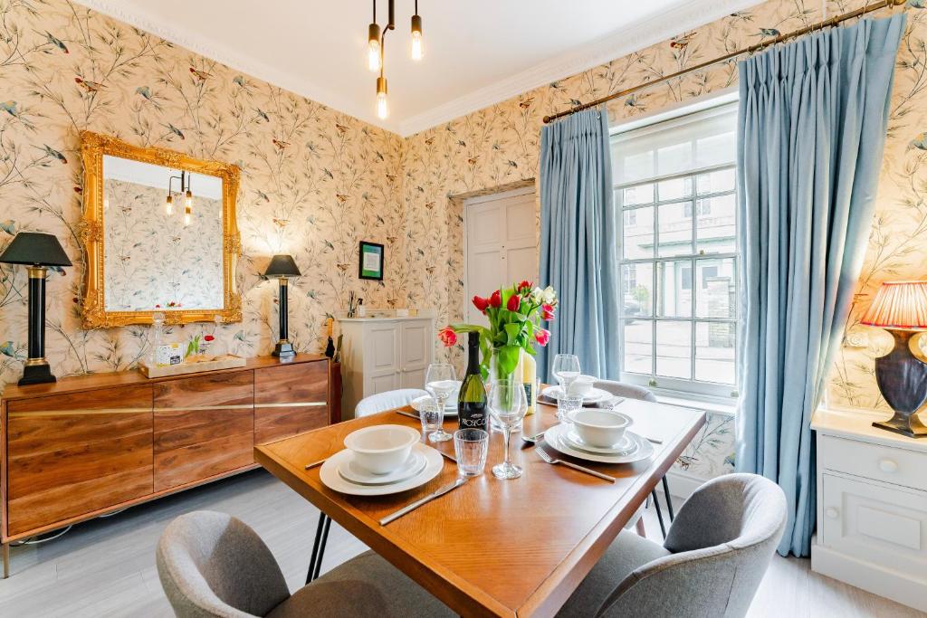 a dining room with a wooden table and chairs at The Old Concert Hall - Norfolk Cottage Agency in Holt