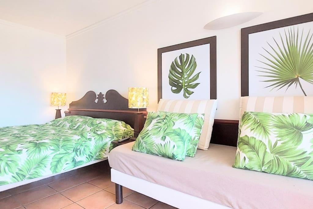 a bedroom with two beds with green leaves at Studio &quot;Prestige&quot; Sainte Luce in Sainte-Luce