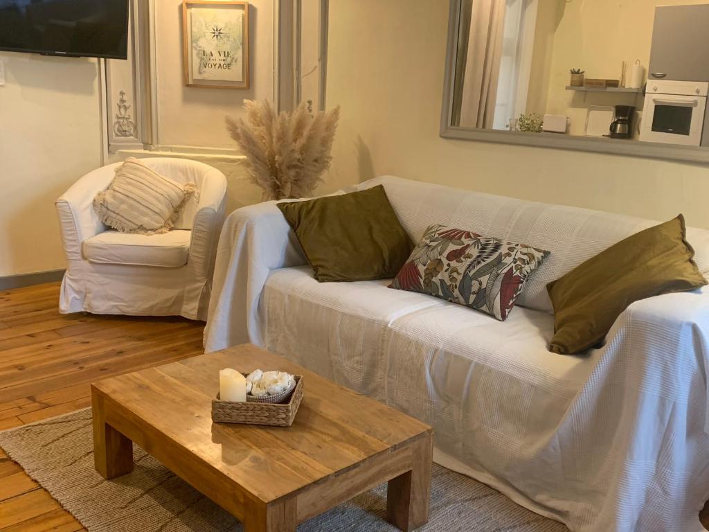 a living room with a white couch and a coffee table at Lou Magnan in L'Isle-sur-la-Sorgue