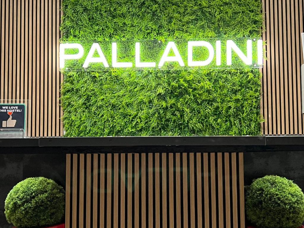 un signo de paladín en un edificio con dos arbustos en Palladini Hostel Rome, en Roma