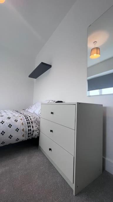 a bedroom with a white dresser and a bed at Filton 6 BDR House for contractors & families. in Bristol