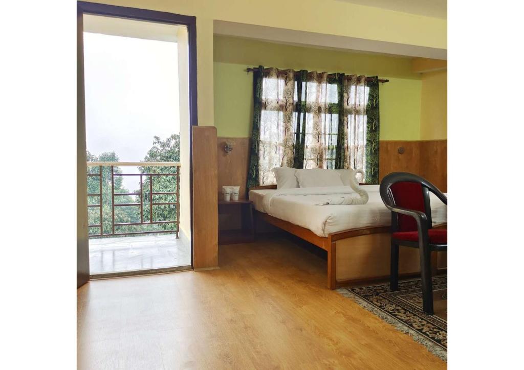 a bedroom with a bed and a large window at Sikkim Heights in Pelling