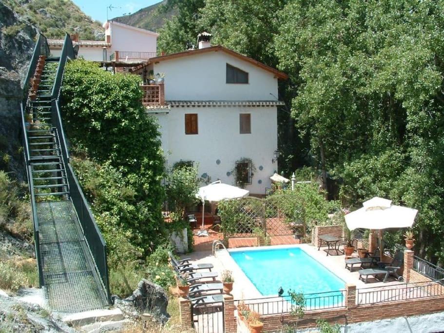 a villa with a swimming pool and a house at Cortijo La Mata in Granada