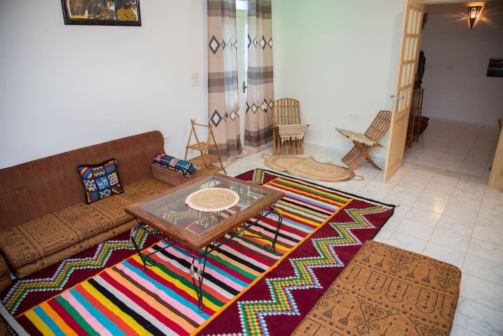 a living room with a couch and a table on a rug at Dar Beya ( APP S+2 ) in Tozeur