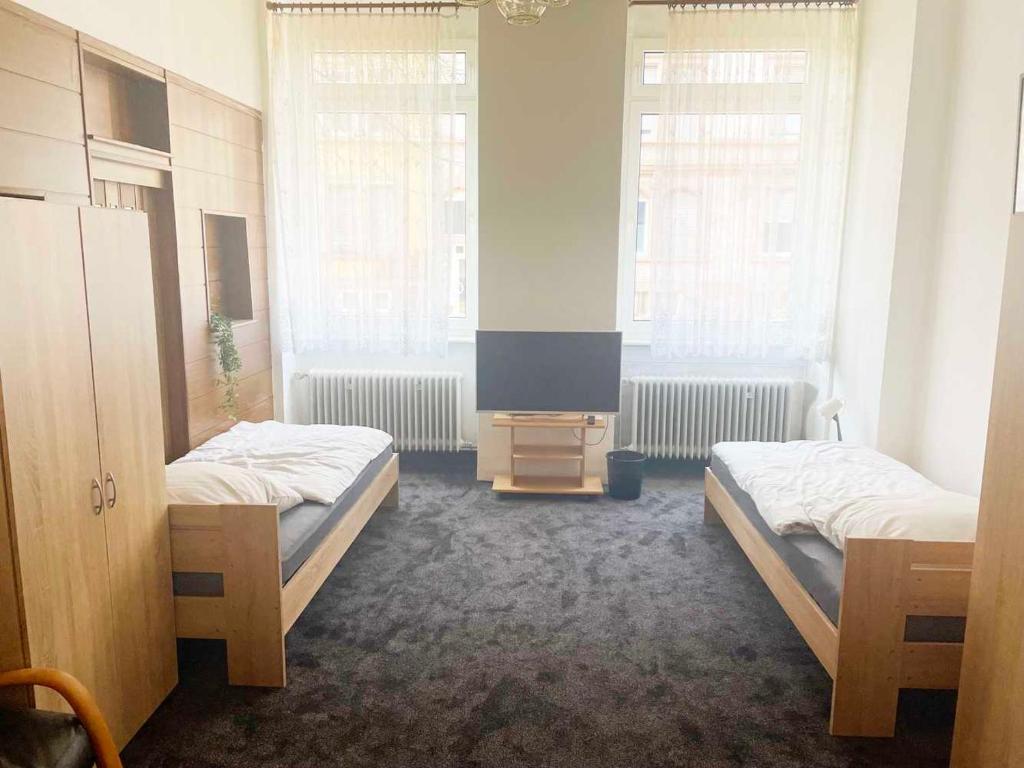 two beds in a room with two windows at Spacious 4 room apartment in Hanau in Hanau am Main