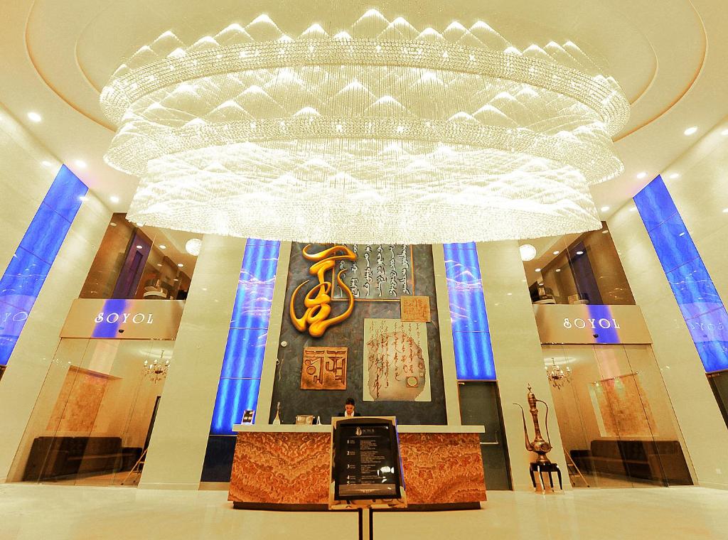 a large chandelier in a building with a cell phone on display at Soyol Hotel in Ulaanbaatar
