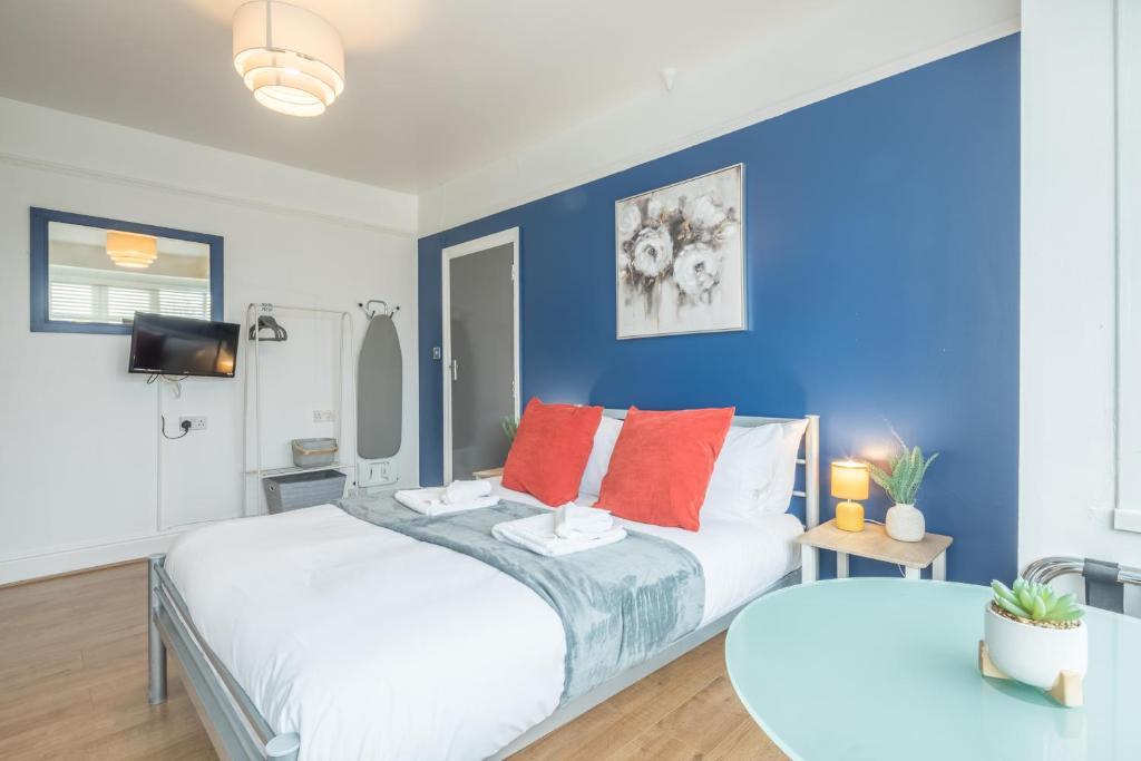 a bedroom with two beds and a blue wall at Cambridge Home Suite 4 in Cambridge