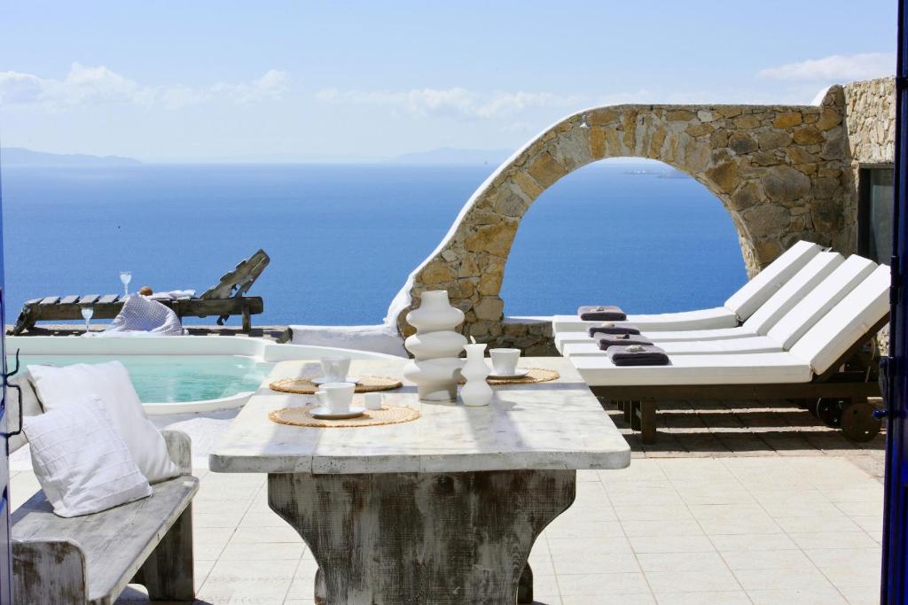 un patio con tavolo e sedie accanto alla piscina di Villa Fos a Fanari