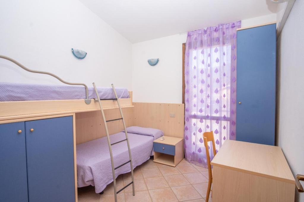 Villetta Porto Corallo Vista Mare في فيلابوتزو: غرفة صغيرة مع سرير بطابقين ومكتب