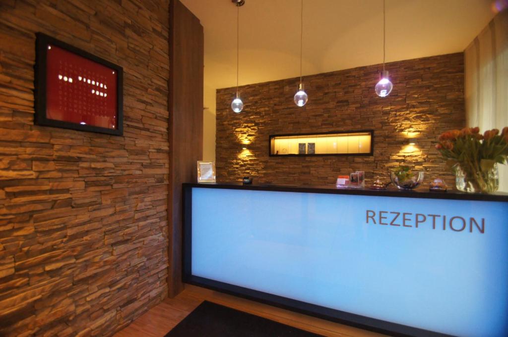 a reception counter in a room with a brick wall at Hotel Deutsches Haus in Bonn