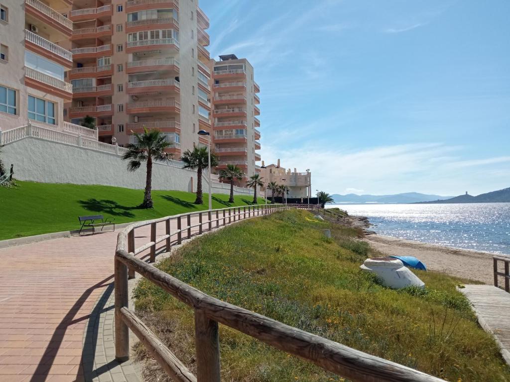 una valla de madera junto a una playa con edificios en PEDRUCHO POINT, menor sea & mediterranean sea views, en La Manga del Mar Menor