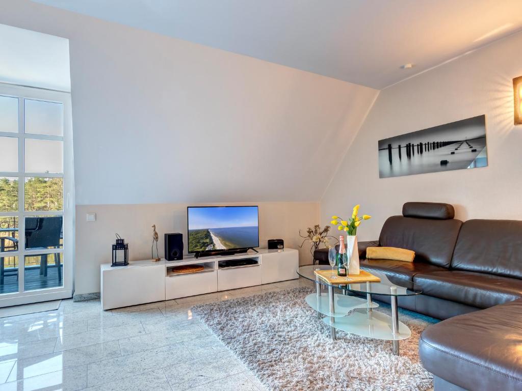 - un salon avec un canapé et une télévision dans l'établissement Residenz am Balmer See - BS 67 mit Wellnessbereich, à Balm