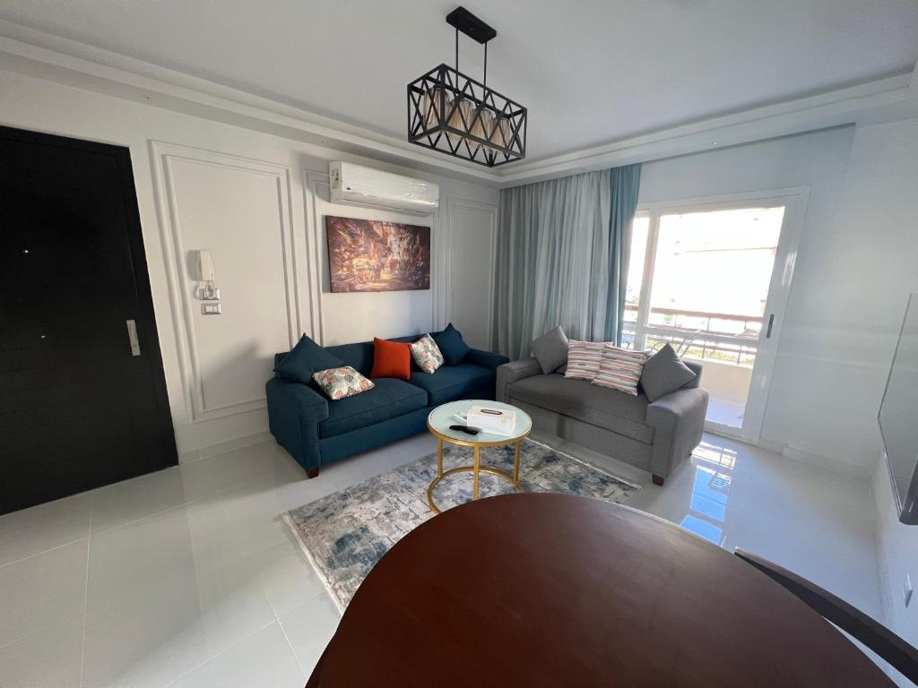 sala de estar con sofá y mesa en Luxury Stylish 2BR Apartment in a world class compound, en Madinaty