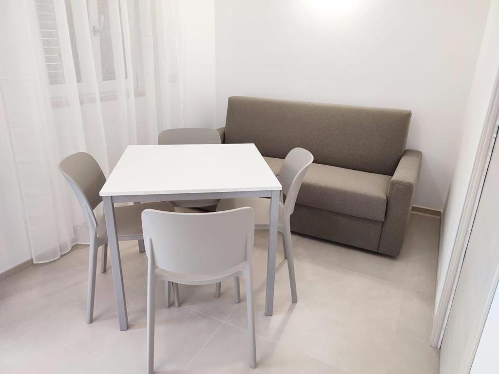 Casa Vacanze Onda Azzurra (Deluxe) في بيسكيتشي: طاولة وكراسي وأريكة في الغرفة
