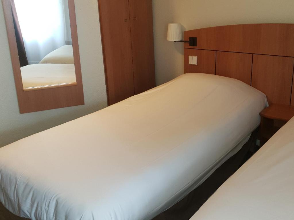Postel nebo postele na pokoji v ubytování Kyriad Montargis Amilly