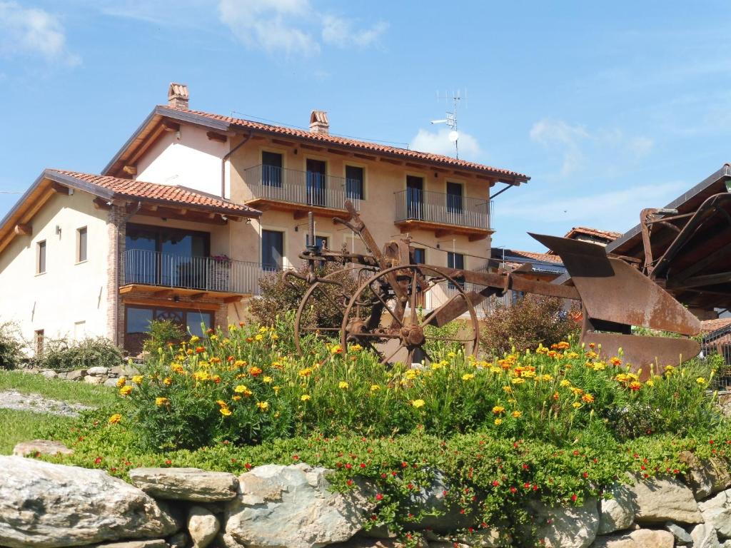 a house with a mill and flowers in front of it at Cascina Coste in Roppolo
