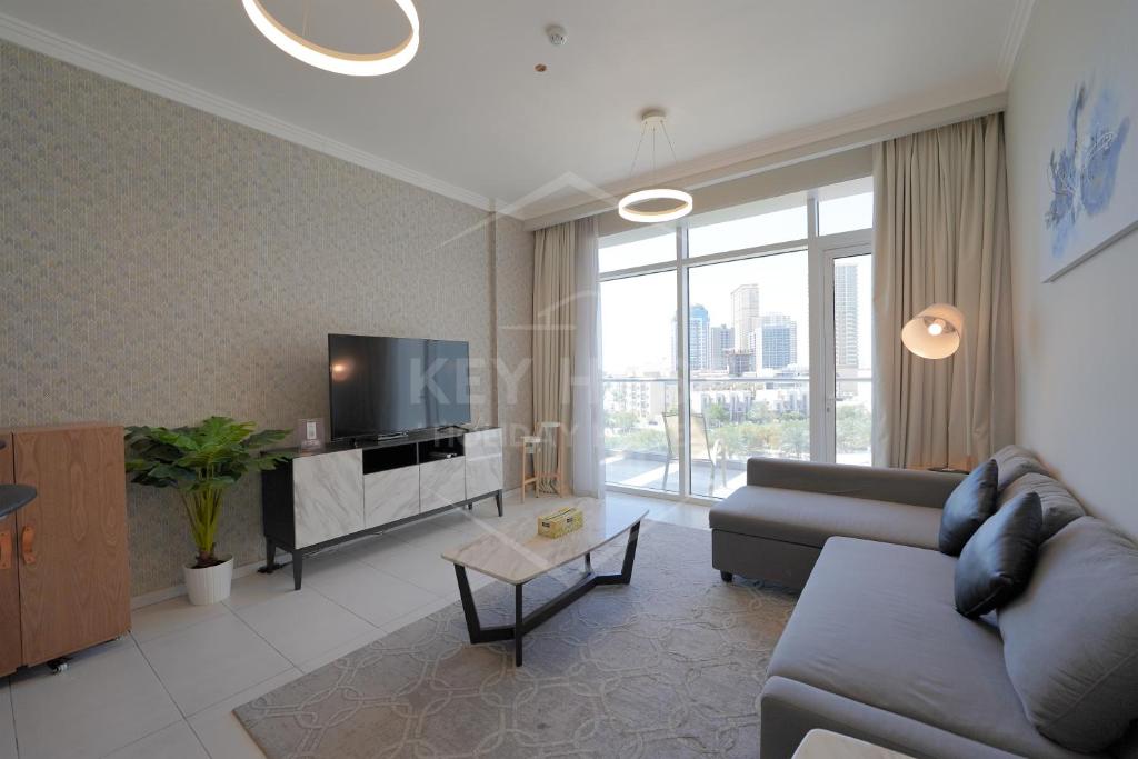 a living room with a couch and a tv at KeyHost - Classy 2BR Apartment near to Five Hotel - JVC - K550 in Dubai