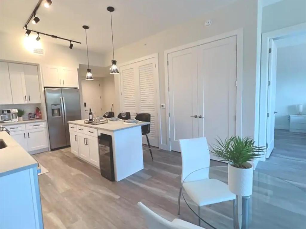 a kitchen with white cabinets and a table and chairs at Lux property great for 1 to 8 Guests-family trip ,5Beds 2Rooms Staycation with Gym and EV, proximity to Downtown and Beaches in West Palm Beach