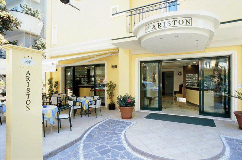 restauracja ze stołami i krzesłami w budynku w obiekcie Hotel Ariston w mieście Misano Adriatico