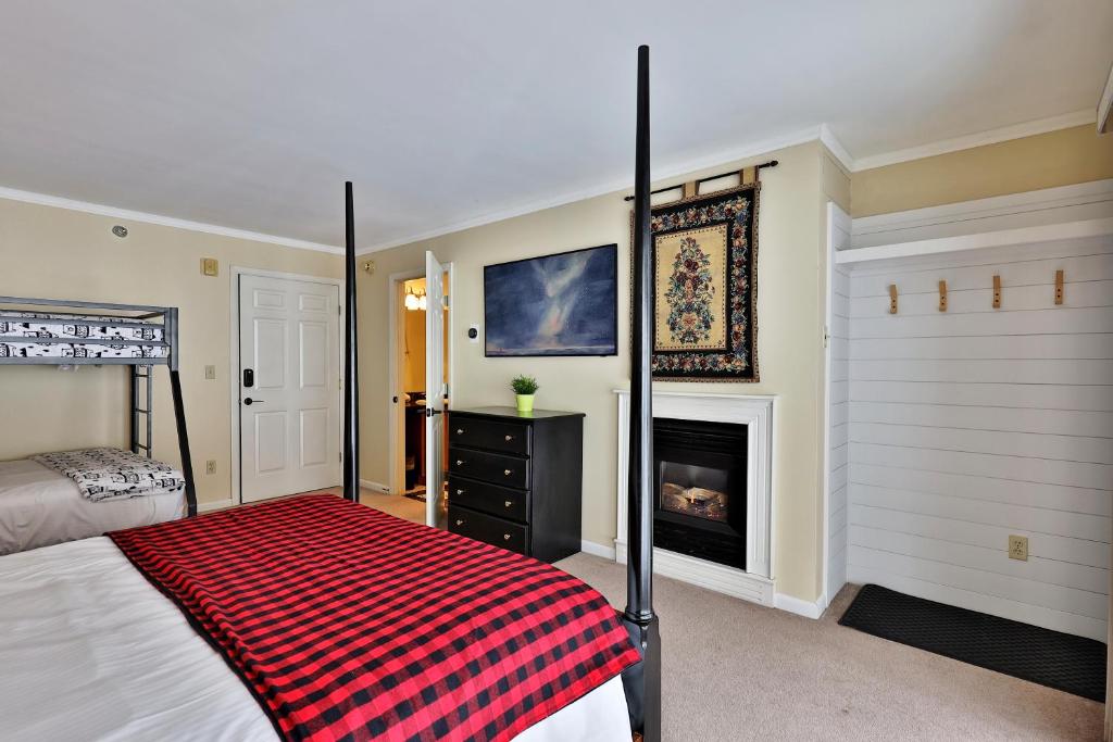 The Birch Ridge- Family Room #6 - Queen Bunkbed Suite in Killington, Vermont Hotel Room في كيلنغتون: غرفة نوم بسرير ومدفأة