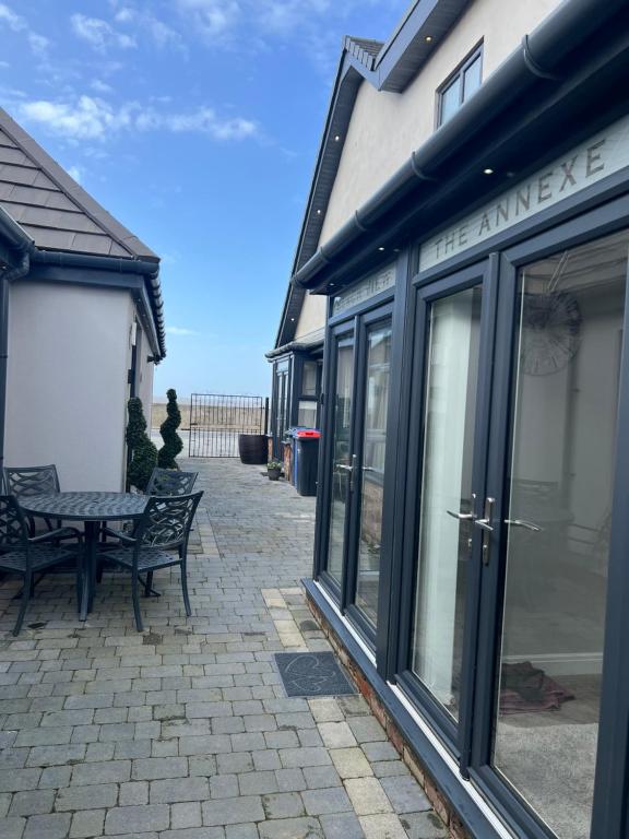 a patio with a bench and a building with glass doors at Beach Pad - ground floor - pet friendly in Cleveleys
