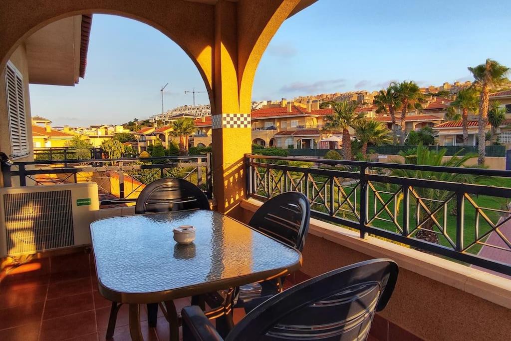 una mesa y sillas en un balcón con vistas en Disfruta de la playa y piscina, acogedora casa, en Santa Pola