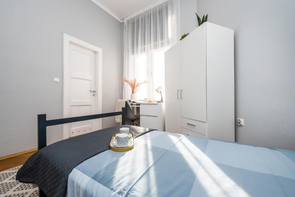 a bedroom with a bed with a clock on it at Wielopole Homes by LoftAffair in Kraków