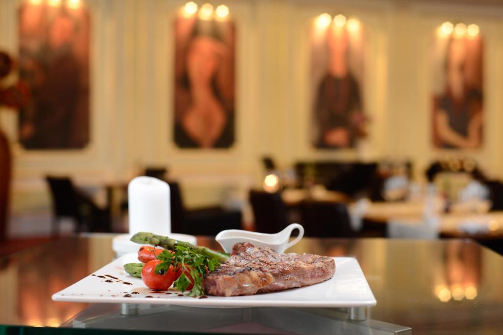 a plate of meat and vegetables on a table at Grand Hotel Bucharest in Bucharest