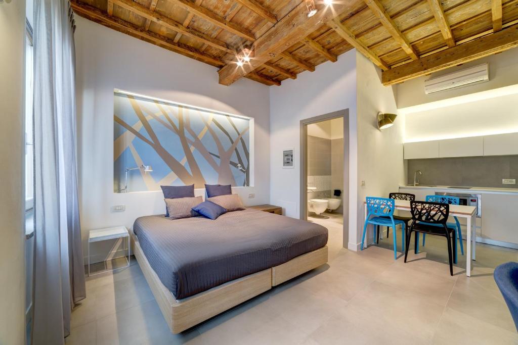 1 dormitorio con cama, mesa y cocina en Palazzo Mannaioni Suites, en Florencia