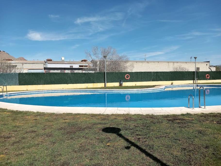 an empty swimming pool in front of a building at El nido del nómada in Atarfe