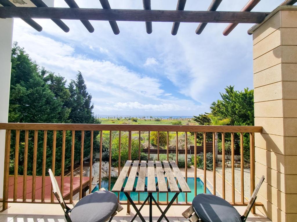 a patio with a wooden table and chairs on a balcony at Sunnyside Pool Villa in Ayia Napa