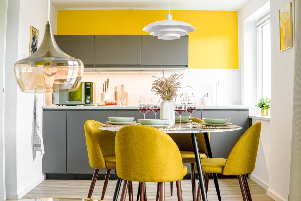 une cuisine avec une table et des chaises jaunes dans l'établissement Homefy Come-Together Apartment - Balkon - Aufzug - Free Parking - Smart TVs, à Essen