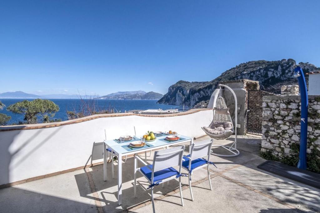 een patio met een tafel en stoelen naast een zwembad bij My home Capri in Capri