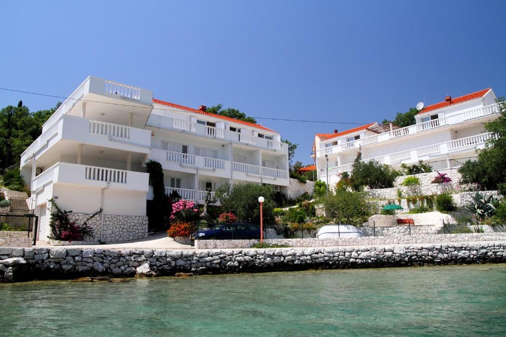 a row of white buildings next to the water at Villa on the Sea Rock in Slano