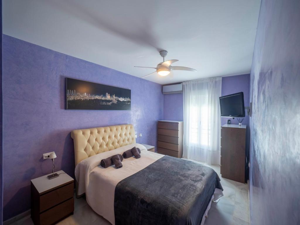 ヘレス・デ・ラ・フロンテーラにあるCenter Luxury fjhomefjの青い壁のベッドルーム1室(ベッド1台付)