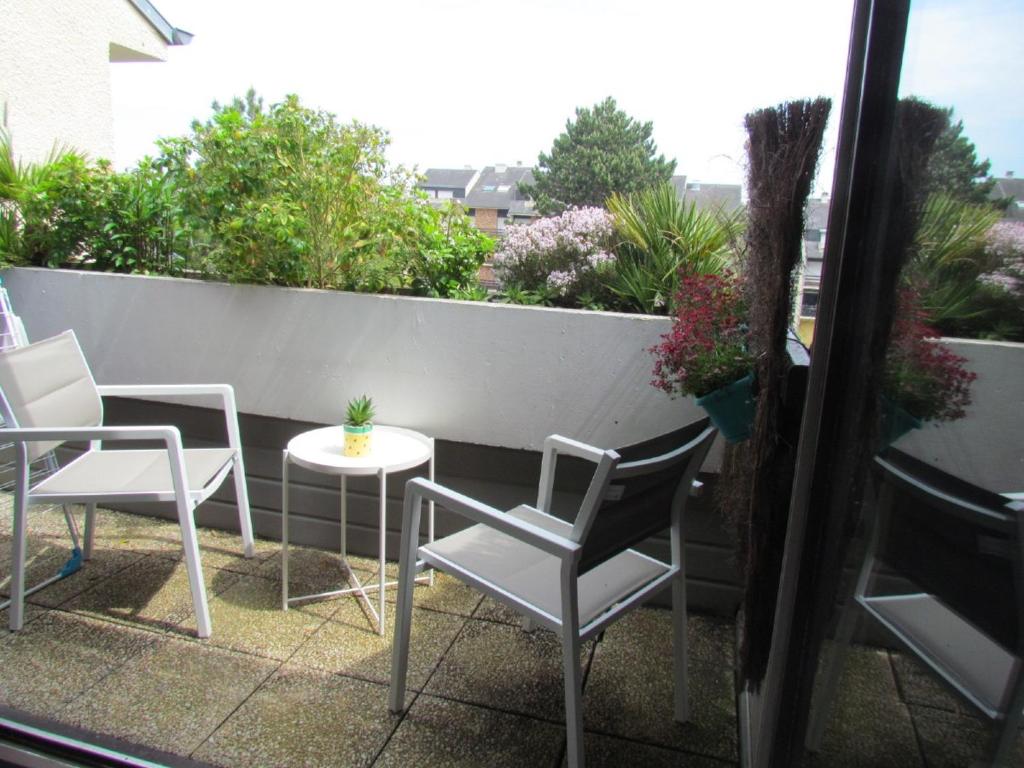 a patio with two chairs and a table on a balcony at Parenthèse Bleue à Cabourg in Cabourg