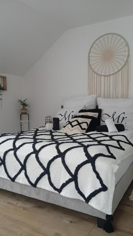 a black and white bed in a white bedroom at Apartament w Pieninach in Krościenko
