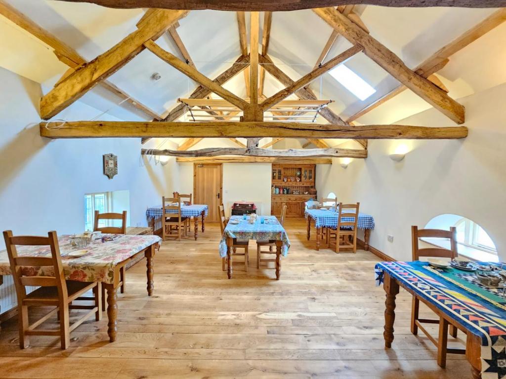 ein Esszimmer mit Holztischen und -stühlen in der Unterkunft Henllys Estate B and B in Llandovery