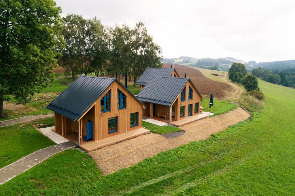 eine Aussicht auf ein Haus auf einem Feld in der Unterkunft Resort Líšenský Dvůr in Sněžné