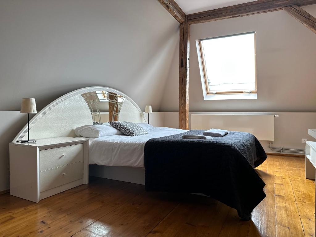 Un dormitorio con una cama blanca y una ventana. en The Spiski Palace Apartments, en Cracovia