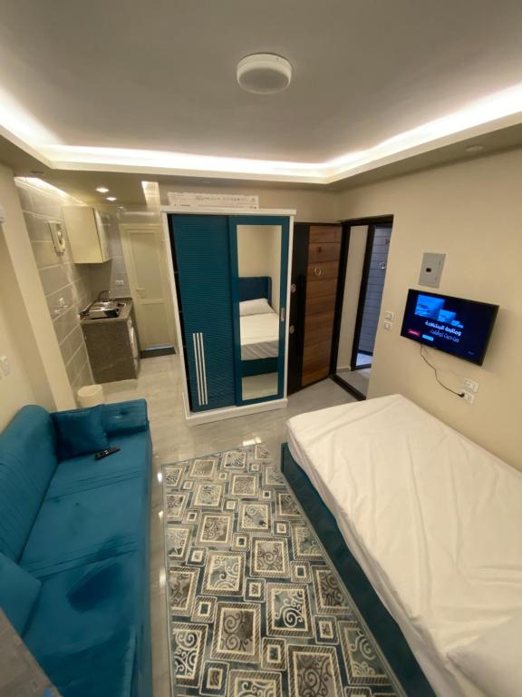 Kleines Zimmer mit einem Bett und einem TV. in der Unterkunft استديو in Madinat as-Sadis min Uktubar