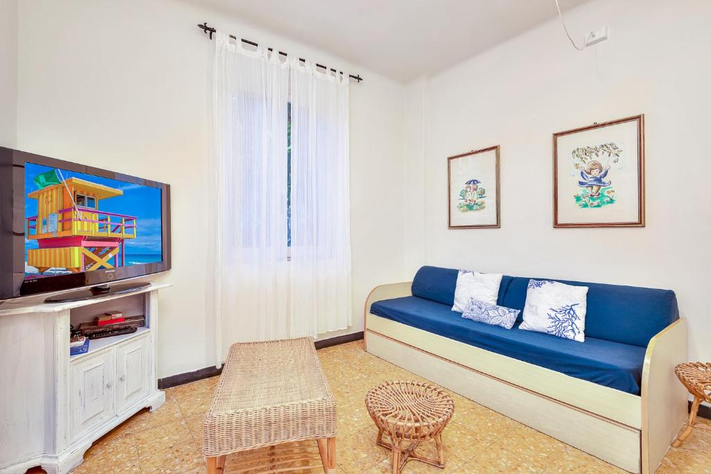 a living room with a blue couch and a tv at Il Verde nel Blu in Monterosso al Mare