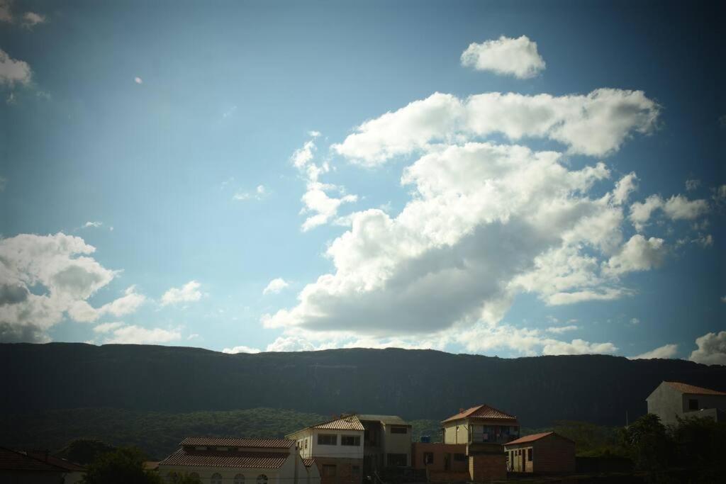 a cloudy sky with buildings and mountains in the background at Loft Aconchego in Tiradentes