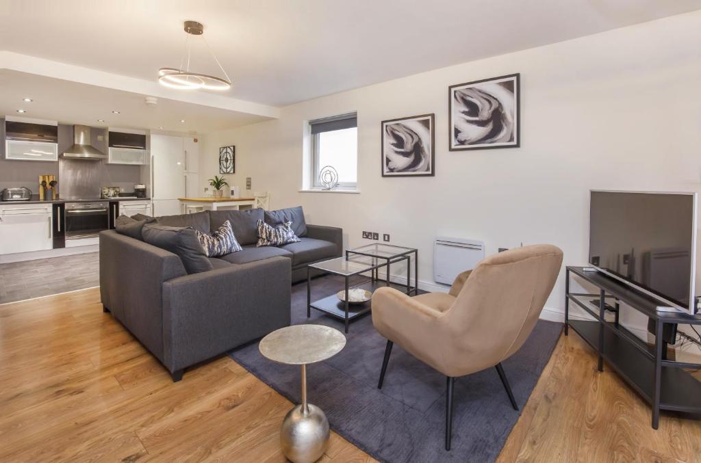 ein Wohnzimmer mit einem Sofa und einem Tisch in der Unterkunft Dixon's Yard, Luxurious City Centre Apartment in York