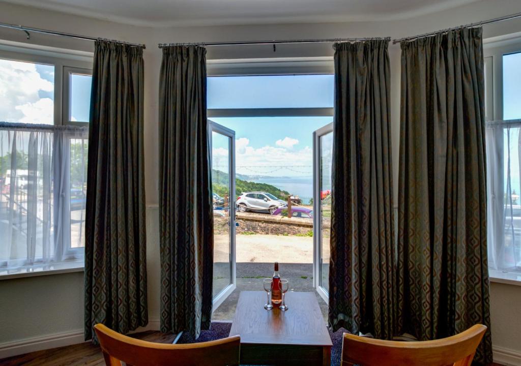 a dining room with a table and a large window at Oddicombe Hall Flat 2 in Torquay