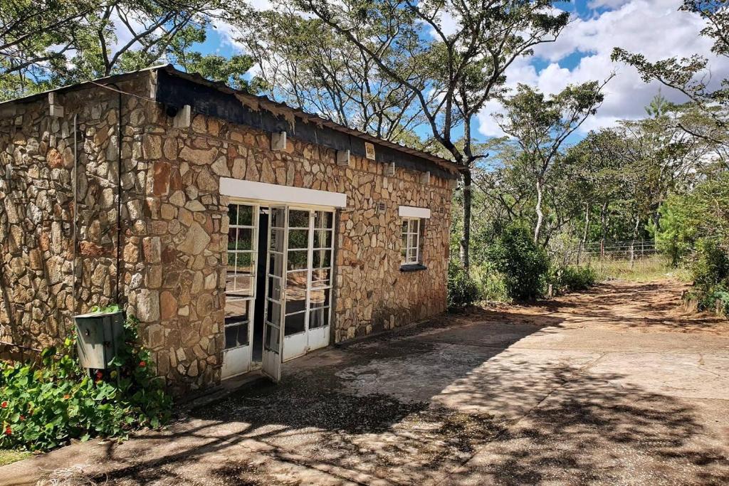 a stone building with a door in a yard at Beautiful 1-Bed Cottage in Juliasdale in Juliasdale