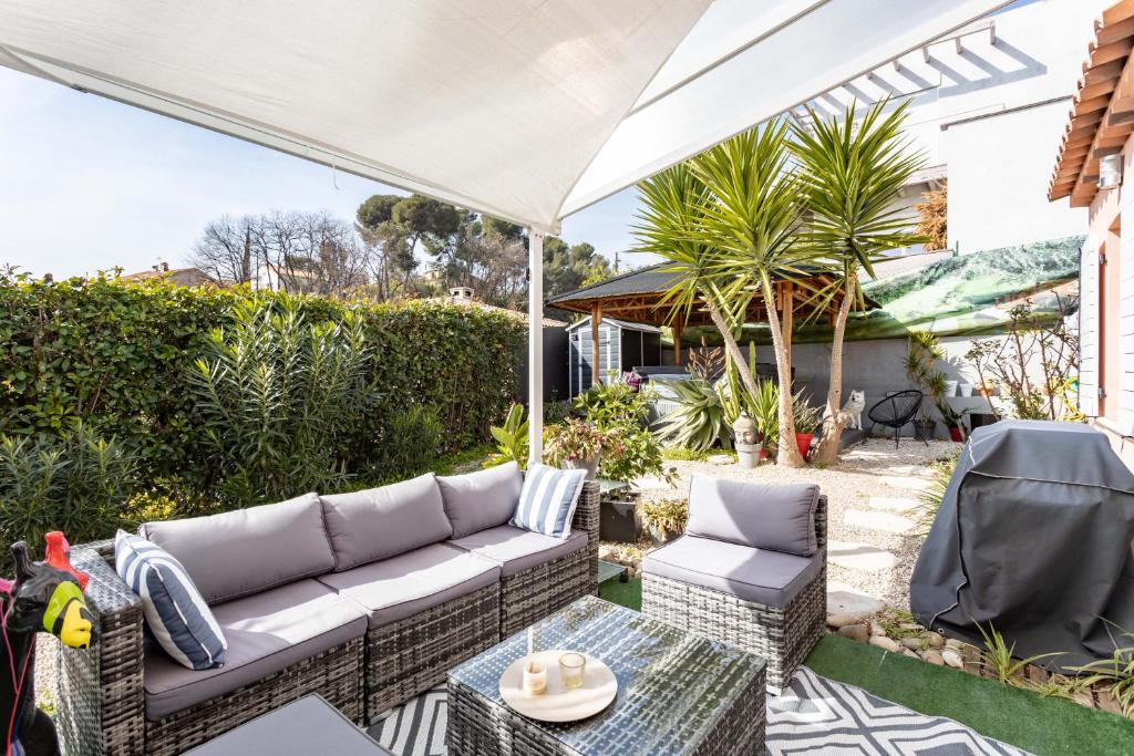 une terrasse avec un canapé et un parasol dans l'établissement Villa tout équipée avec SPA, à Cagnes-sur-Mer