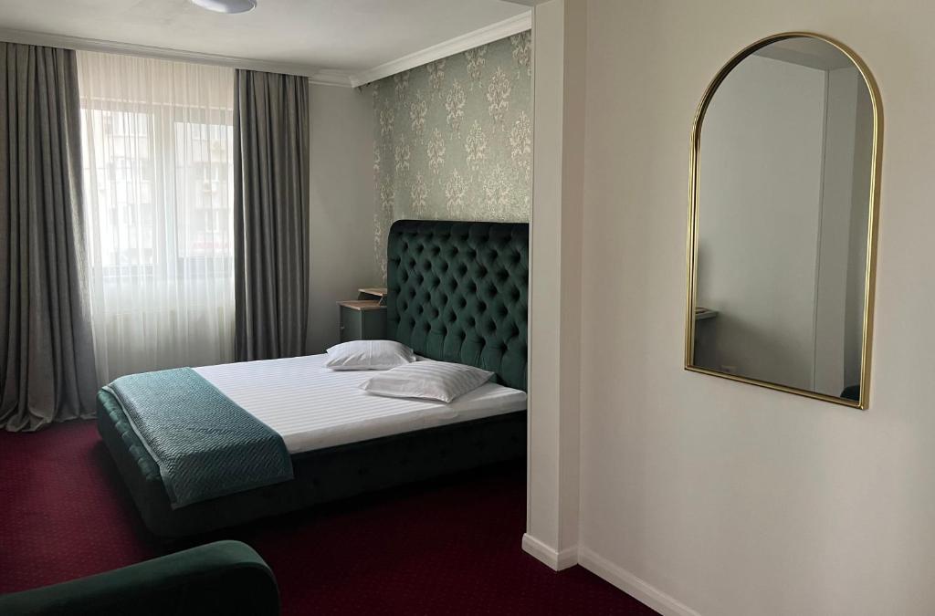 ブカレストにあるEden Boutique Accommodationのベッドと鏡が備わるホテルルーム