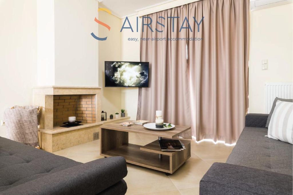 a living room with a couch and a table at Thresh Apartments Airport by Airstay in Spáta